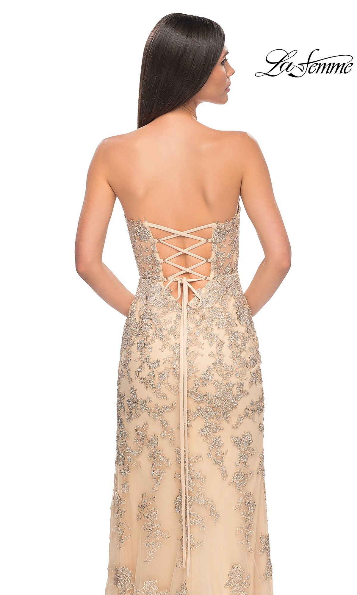 A woman faces away in the La Femme Sheer-Corset Long Prom Dress 32013, featuring a nude strapless sweetheart neckline, silver lace embroidery, and lace-up back. The La Femme logo appears in the top right corner.